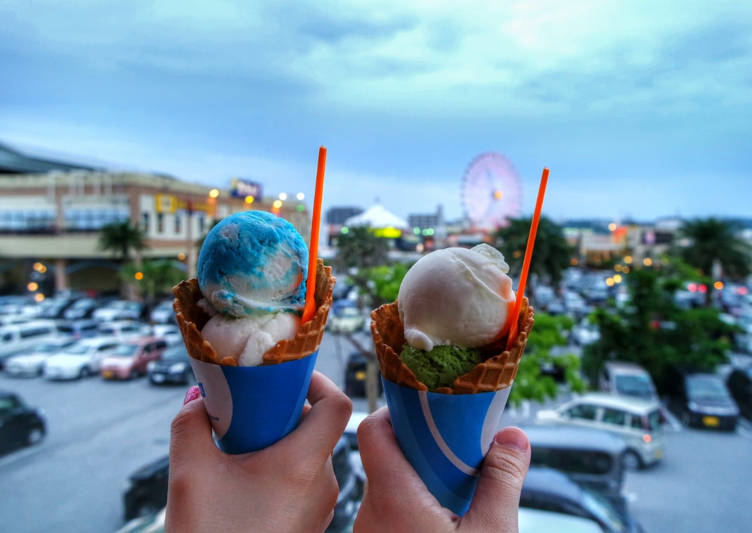 close-up of two hands holding two ice-cream cones