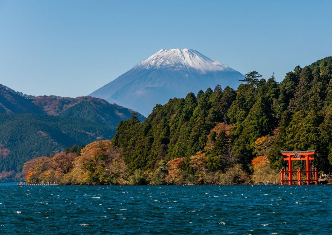 Mt. Fuji and a big red Torii gate on a Lake under blue clear sky background