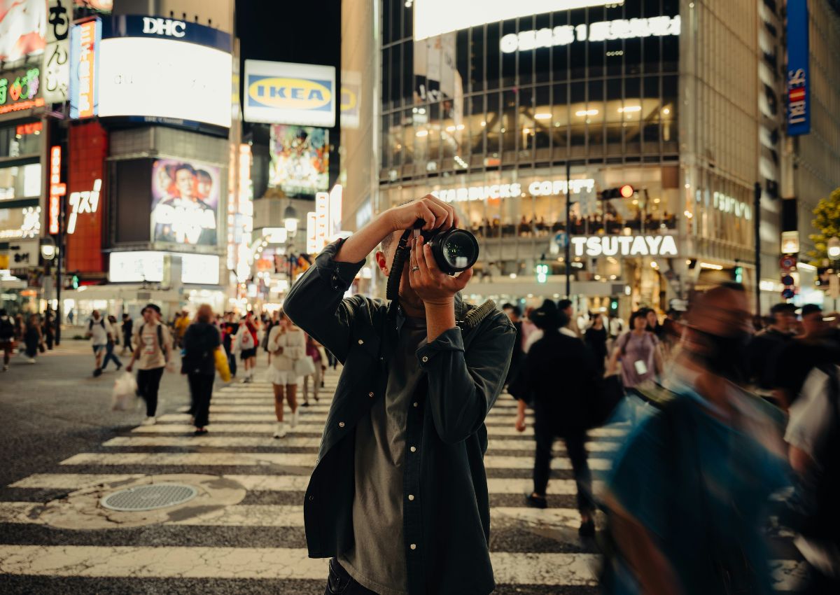 Man holding up camera in Shibuya Crossing, Tokyo