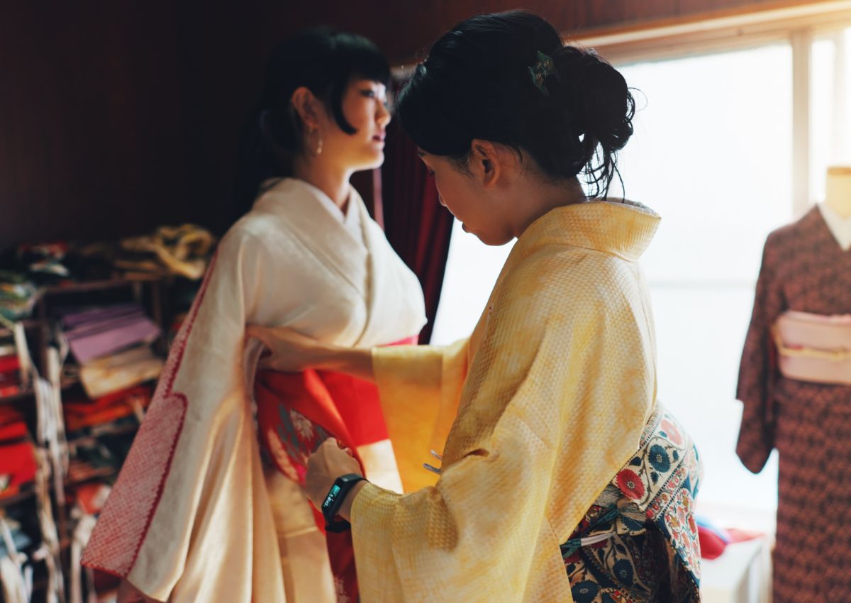 Woman dressing another woman in kimono