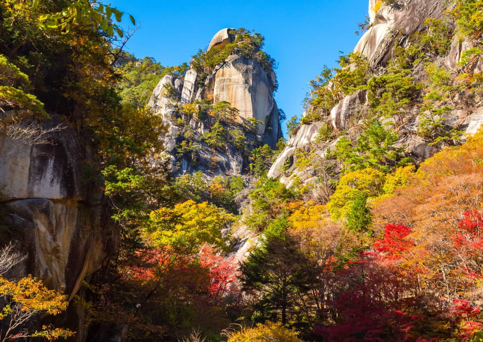 Passage in the middle of two large rocks in autumn, Shosenkyo Gorge in Japan.