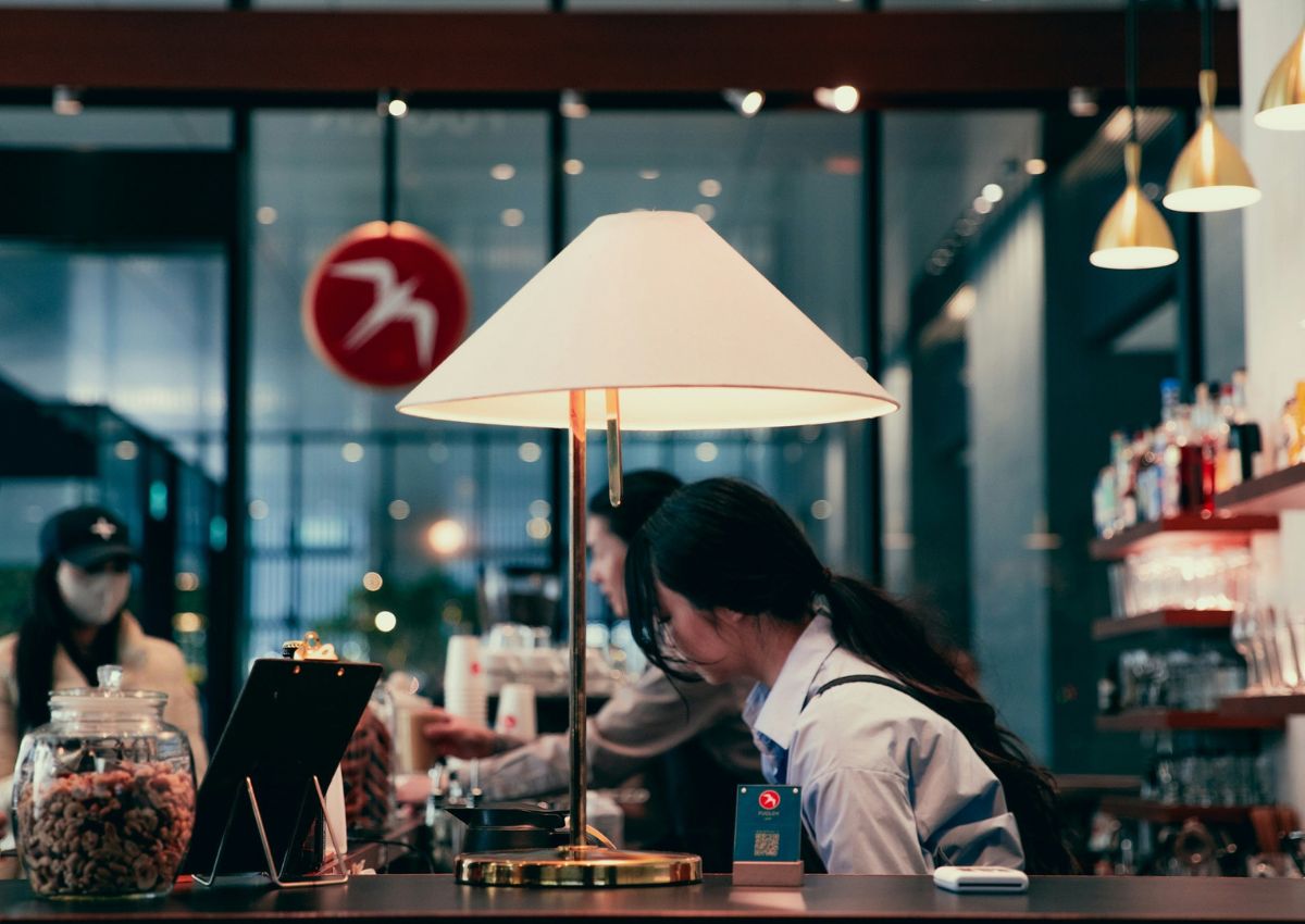 Two baristas preparing drinks behind the coffee counter inside Fuglen Tokyo