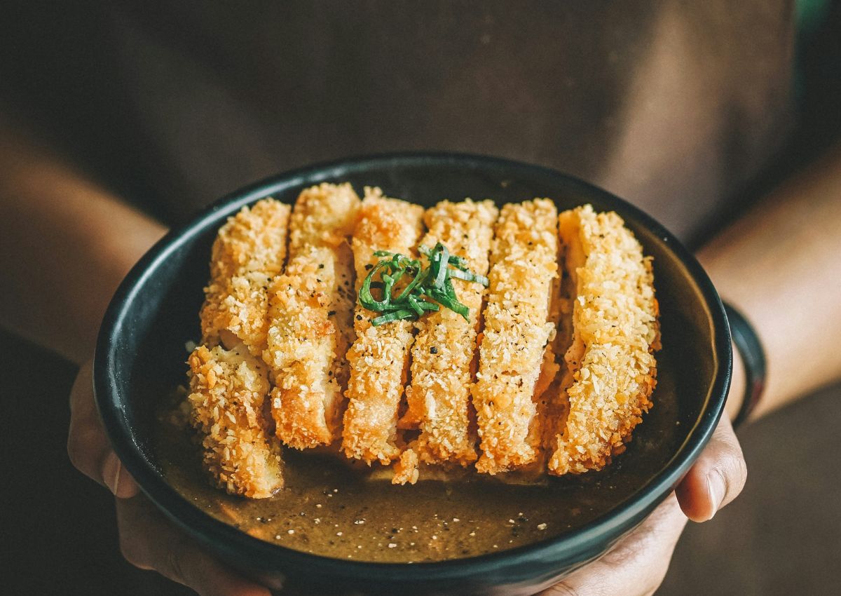 Woman holding a bowl of Japanese cutlet curry