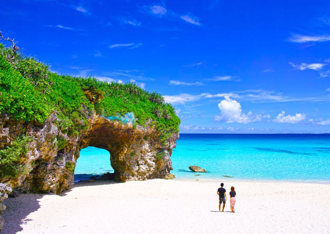 Miyako-jima in summer. A couple watching the ocean at Sunayama beach.