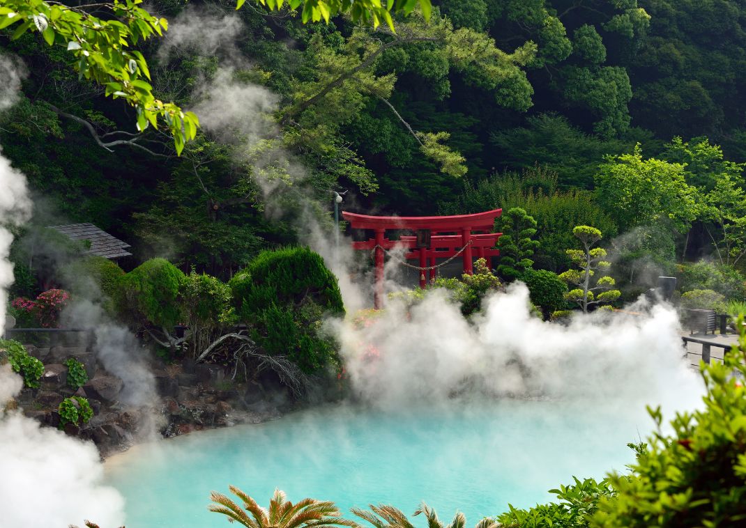  Cyan coloured hot spring in Beppu with a red torii gaten