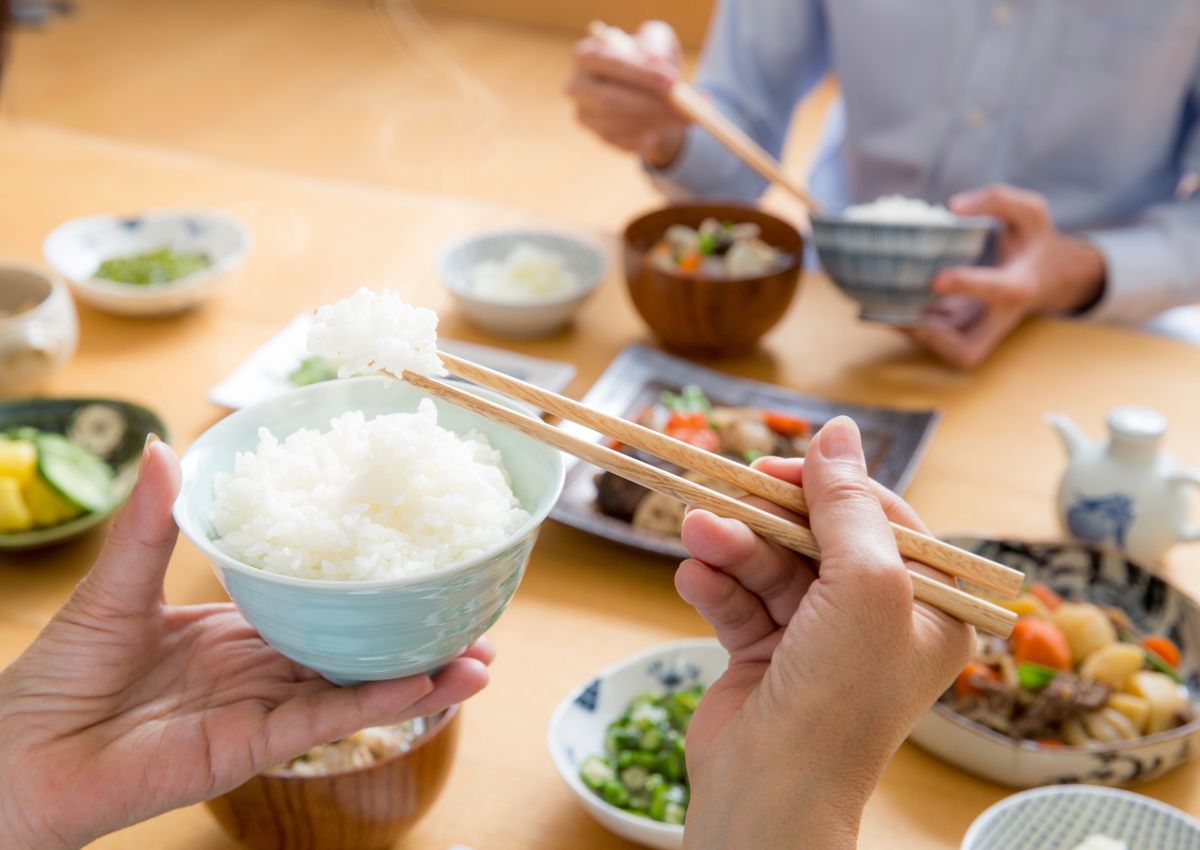 Japanese person holding a bowl of steamed rice