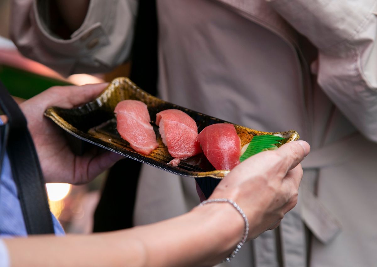 Woman holding fresh sushi at Tsukiji Fish Market, Tokyo