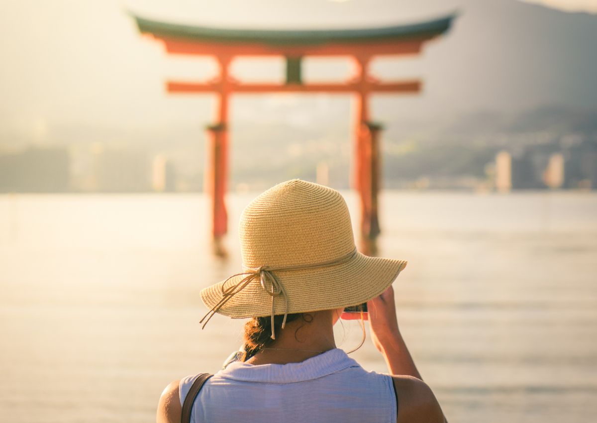 Tourist taking photo at Great Torii gate on Miyajima Island