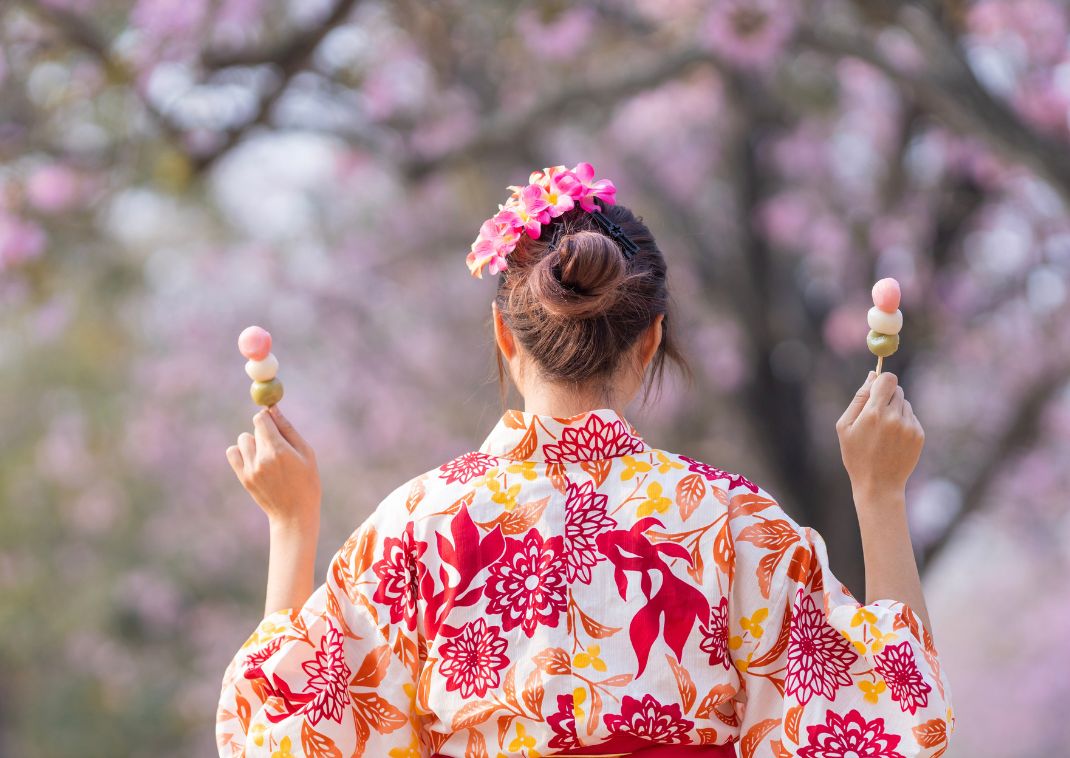 Lady wearing traditional Japanese clothing holding Japanese desserts