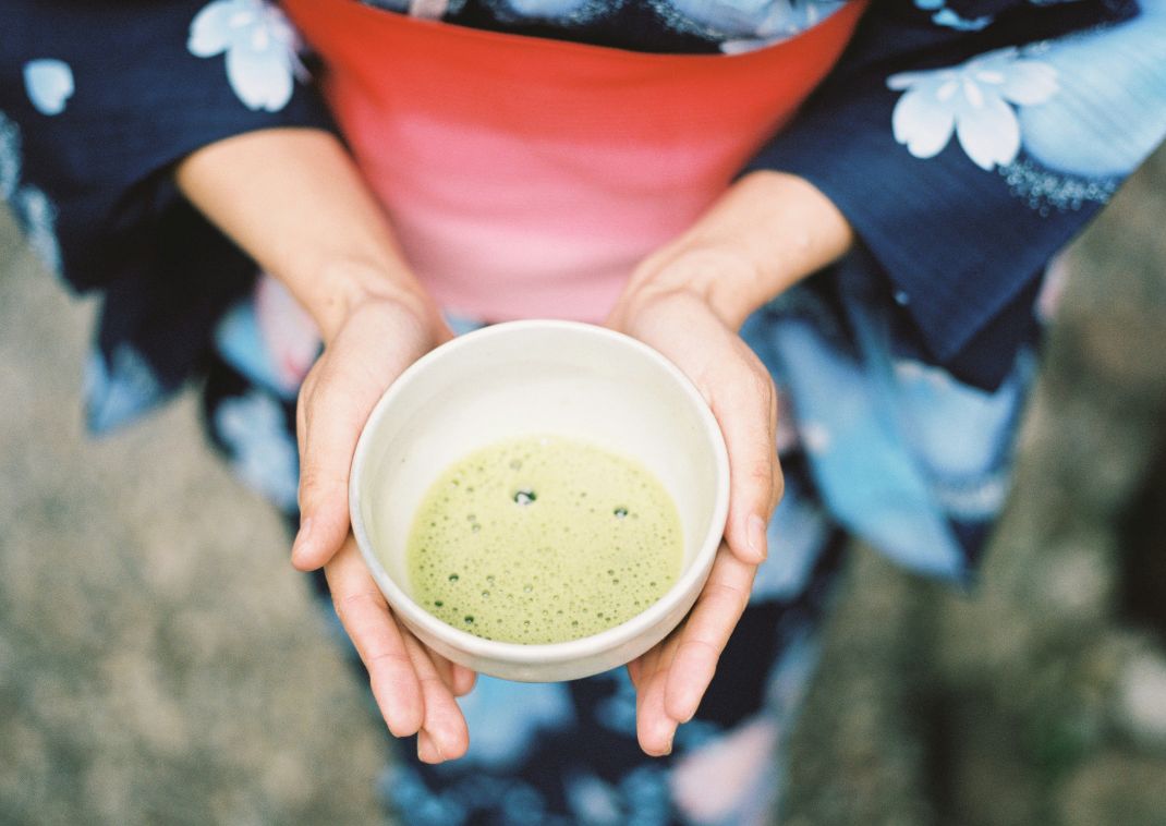 Japanese person holding a teacup.