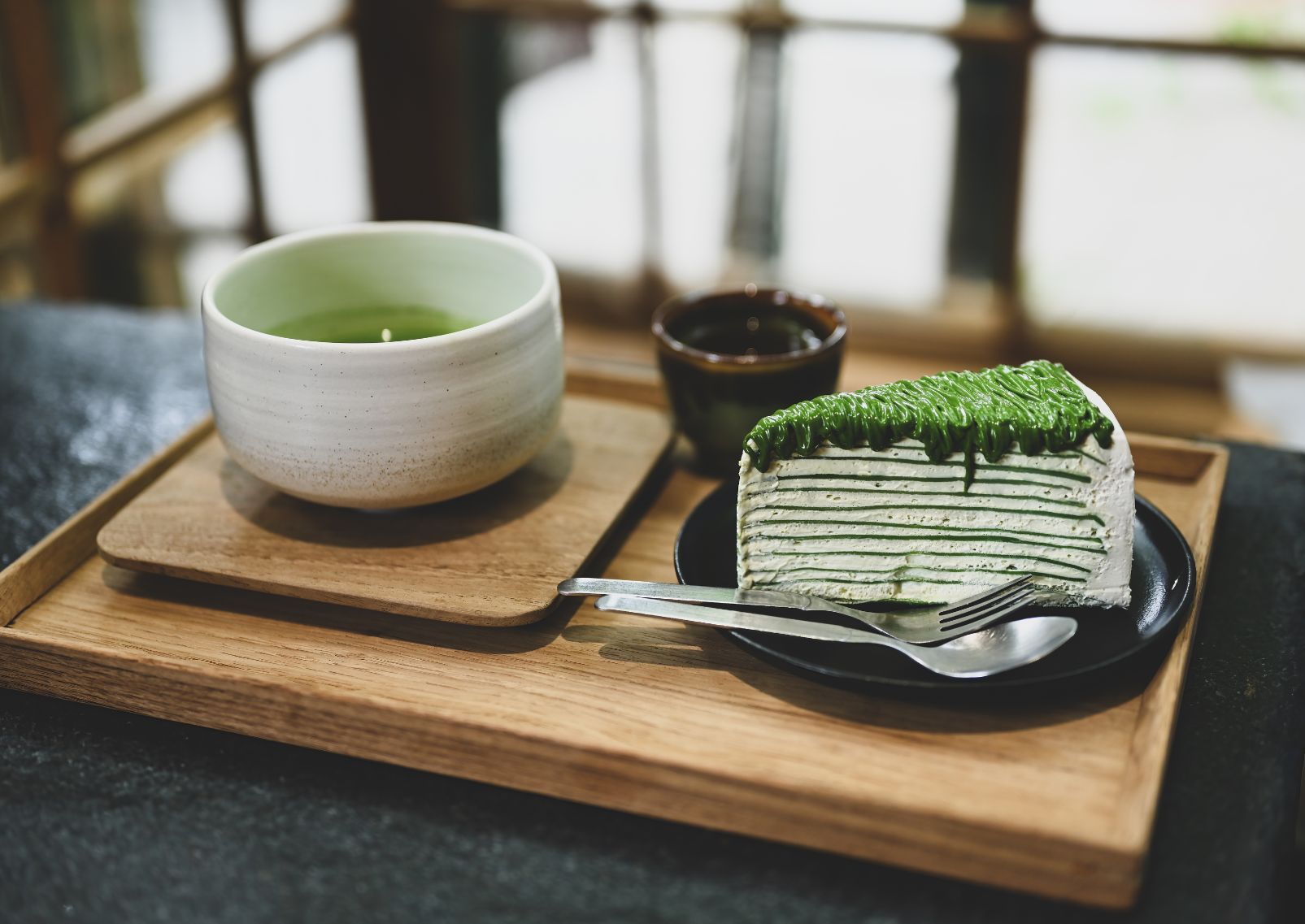 A slice of Matcha cake with Genmaicha Uji latte in the Japanese traditional ceramic bowl