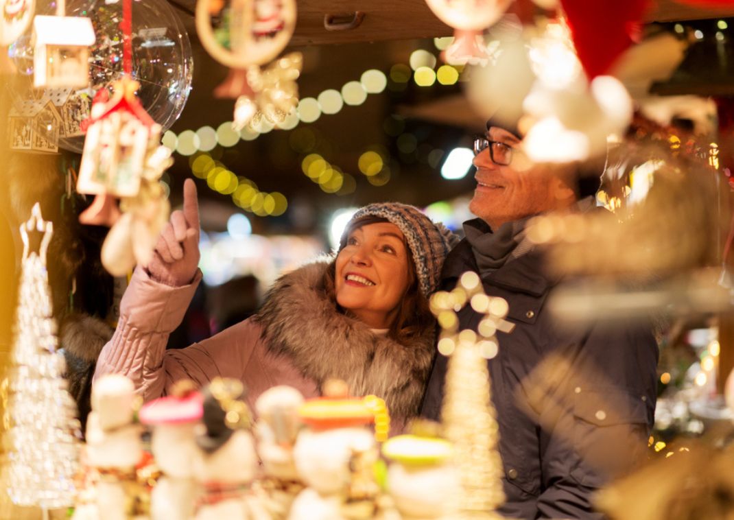 Happy couple looking at items at a Christmas market