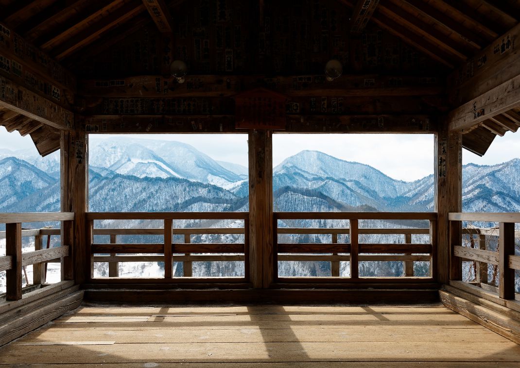 A panoramic view of snow-covered winter mountains from inside the Godaido Hall.