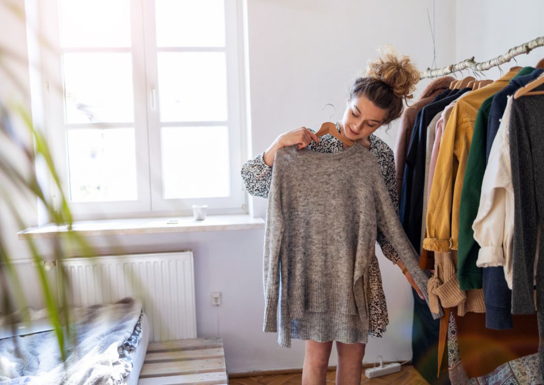 Woman deciding what to wear at home before packing