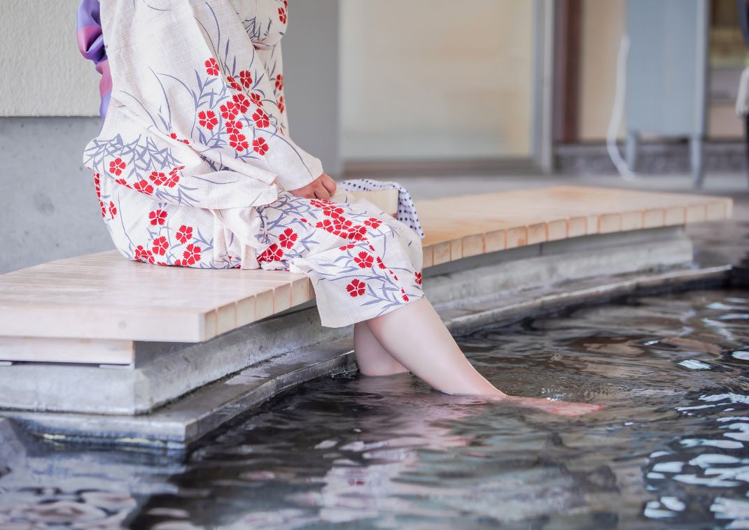 Woman in yukata enjoying a steaming foot bath in Japan