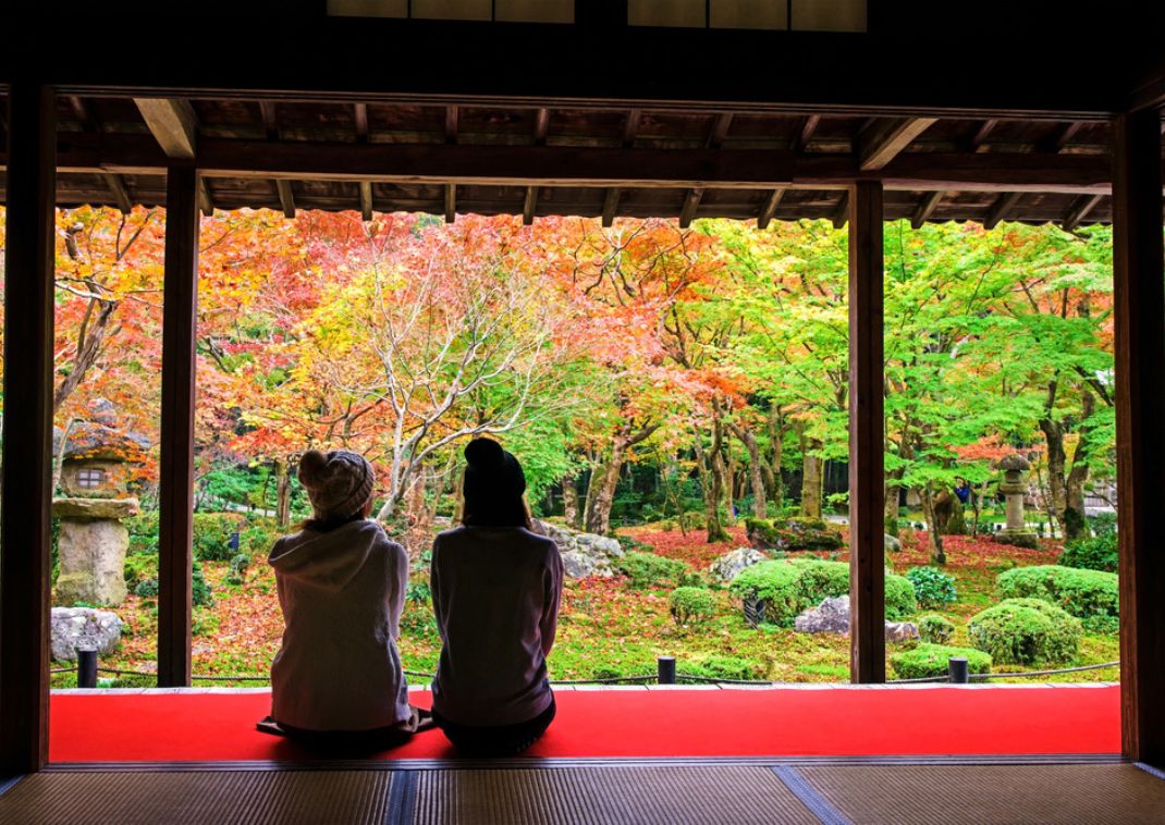 Two girls sitting in Enkoji Tempe and Garden, Kyoto, Japan