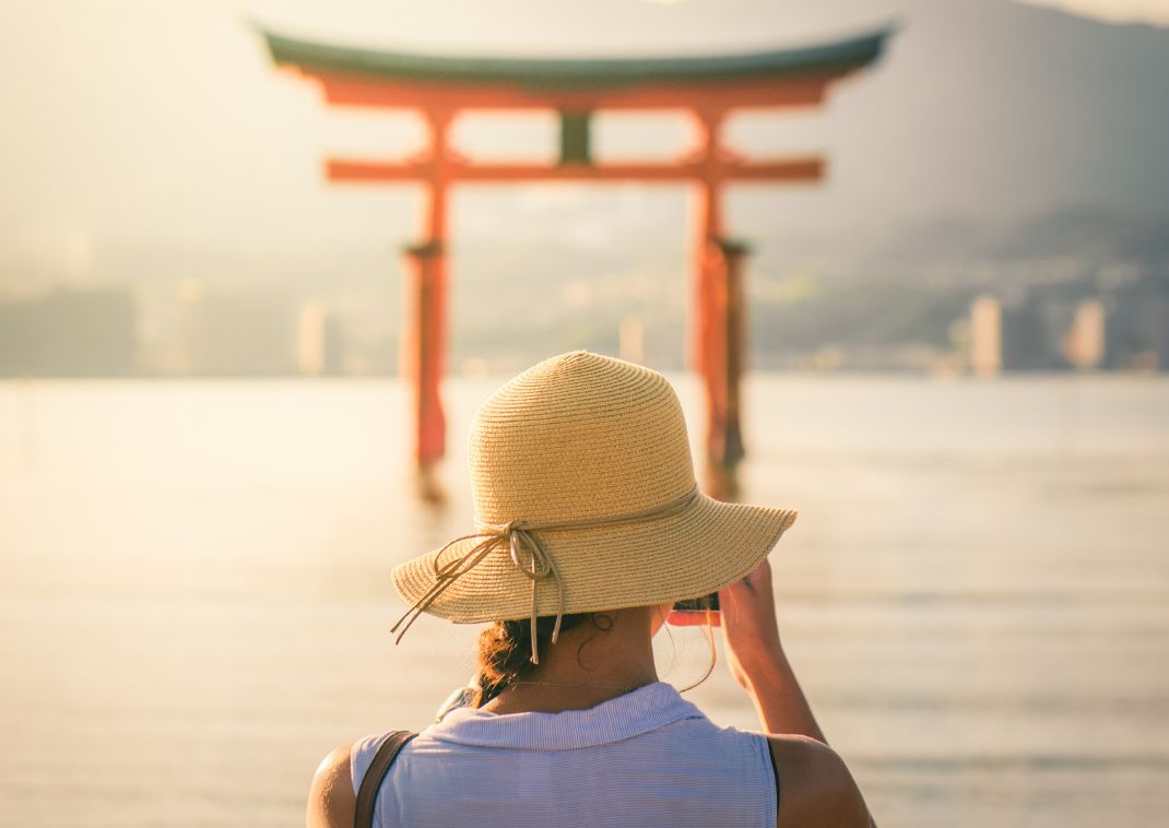 Girl photographing sunset at Miyajima Island, Japan