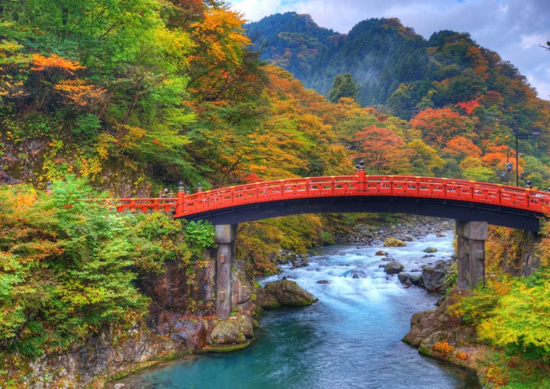 Red bridge against autumn foliage in Nikko, Japan, in autumn