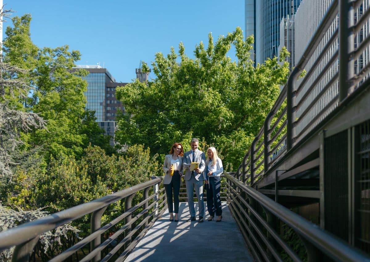 People walking on bridge with greenery