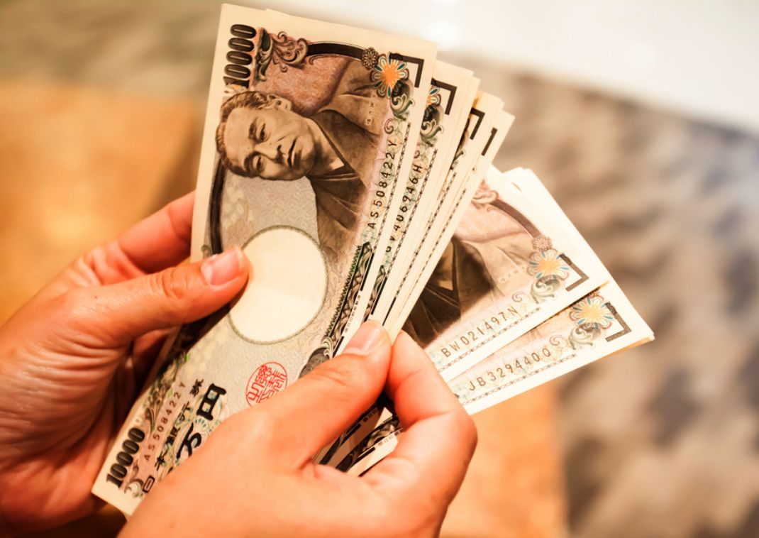Hands fanning out Japanese yen