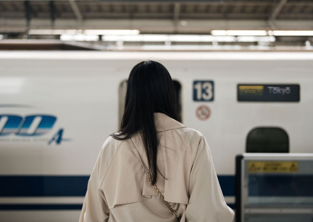 Woman in front of a shinkansen train at Tokyo Station, Japan
