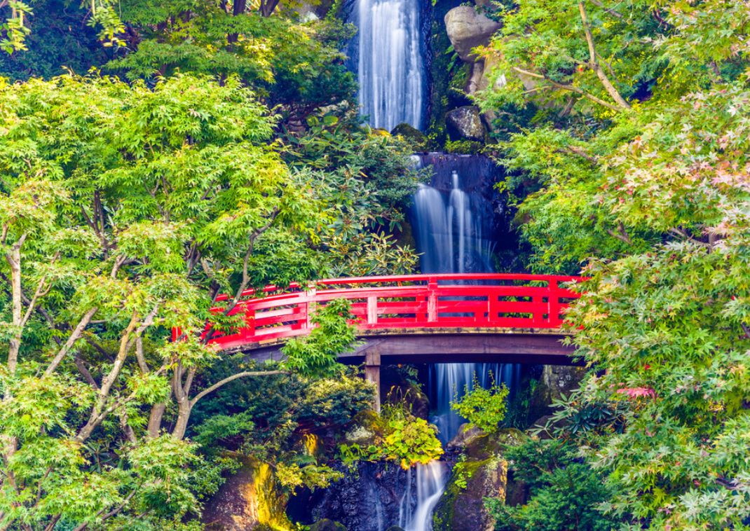 Waterfall scene in Japan with red bridge