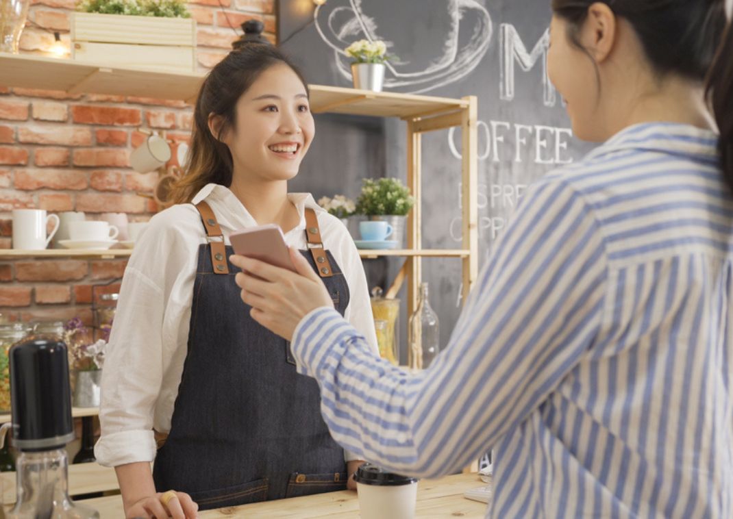 Asian female barista serving a customer