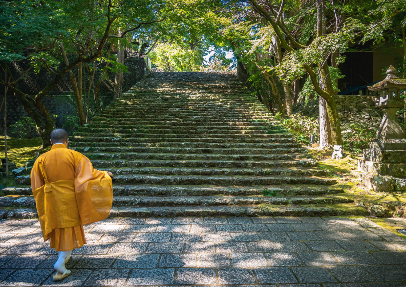 Buddhist priest walk up stairs at Chikurin-ji Temple in Kochi