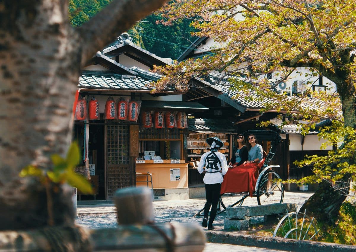 Two tourists riding a Japanese rickshaw in Kyoto