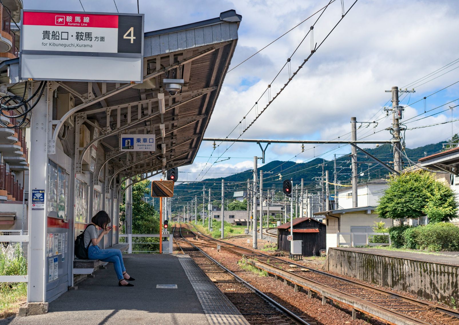 Girl on her mobile phone at train station in Kyoto, Japan