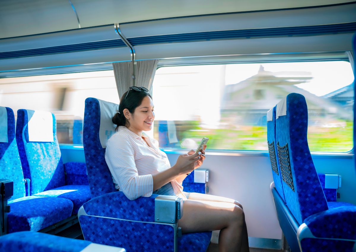 Tourist girl smiling sitting on a shinkansen train, Japan
