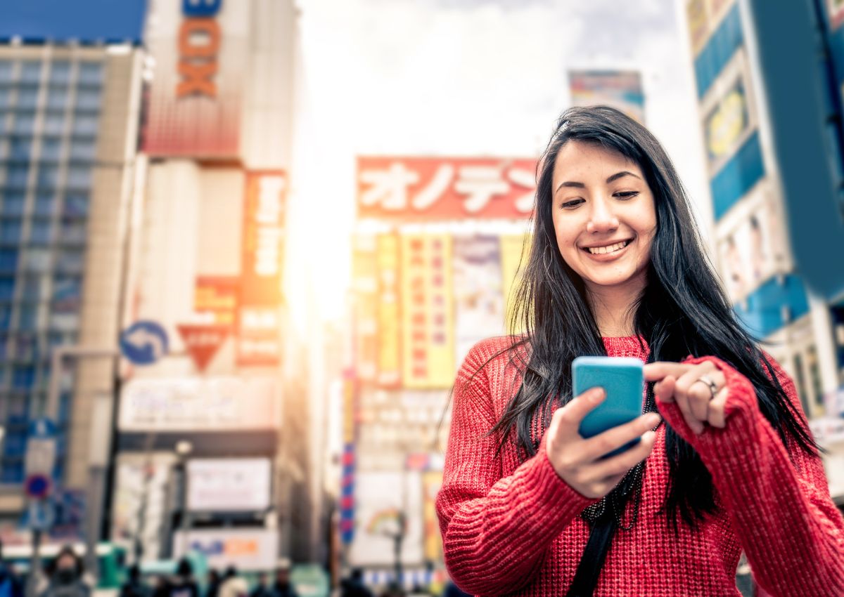 Girl holding phone in Tokyo, Japan