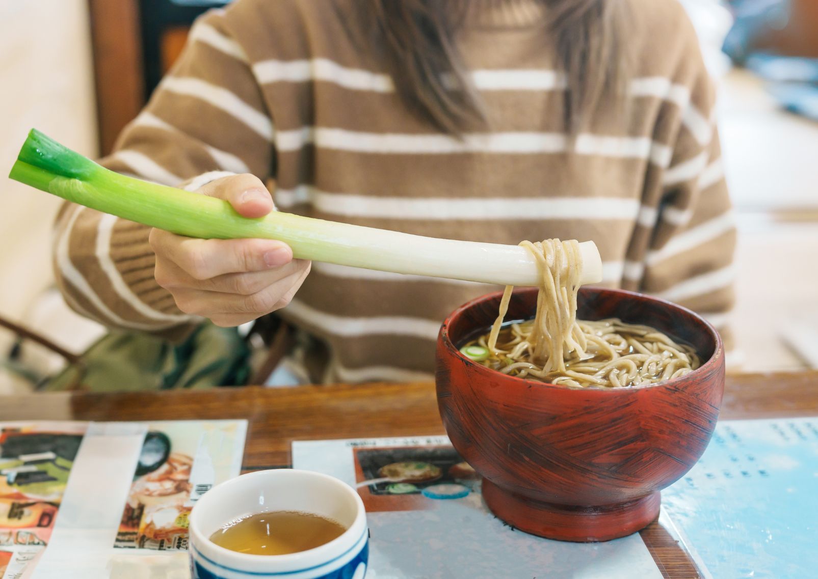  Girl eating negi soba buckwheat soup in Ouchi-juku village, Fukushima, Japan