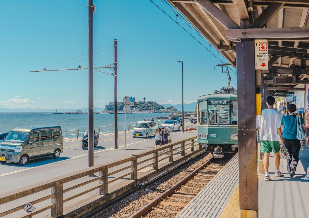 Tourists waiting for the train at seaside train station in Kamakura, Kanagawa, Japan