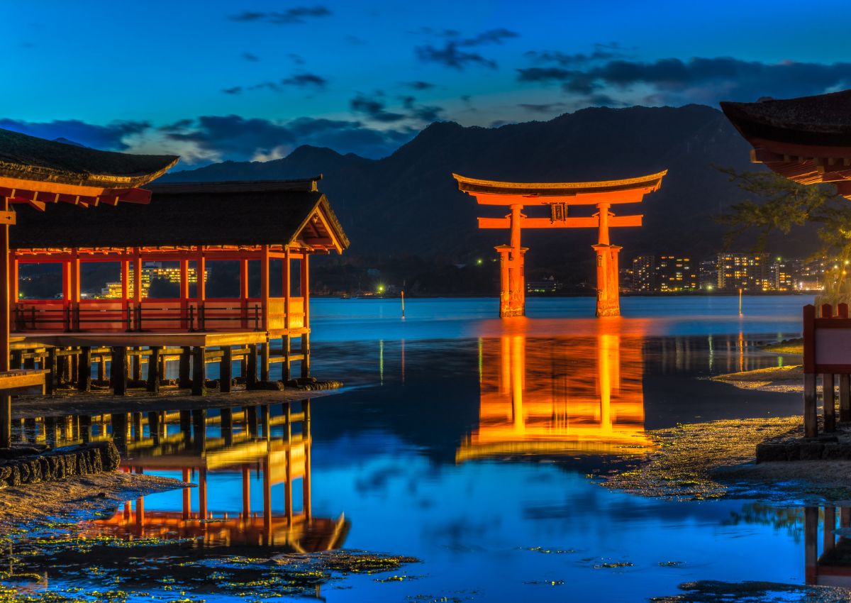 Itsukushima Shrine buildings and floating torii gate at night