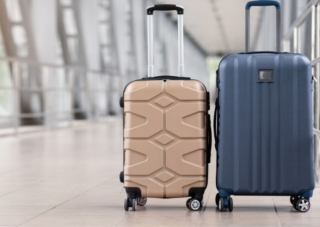 Two suitcases standing side by side in a lobby