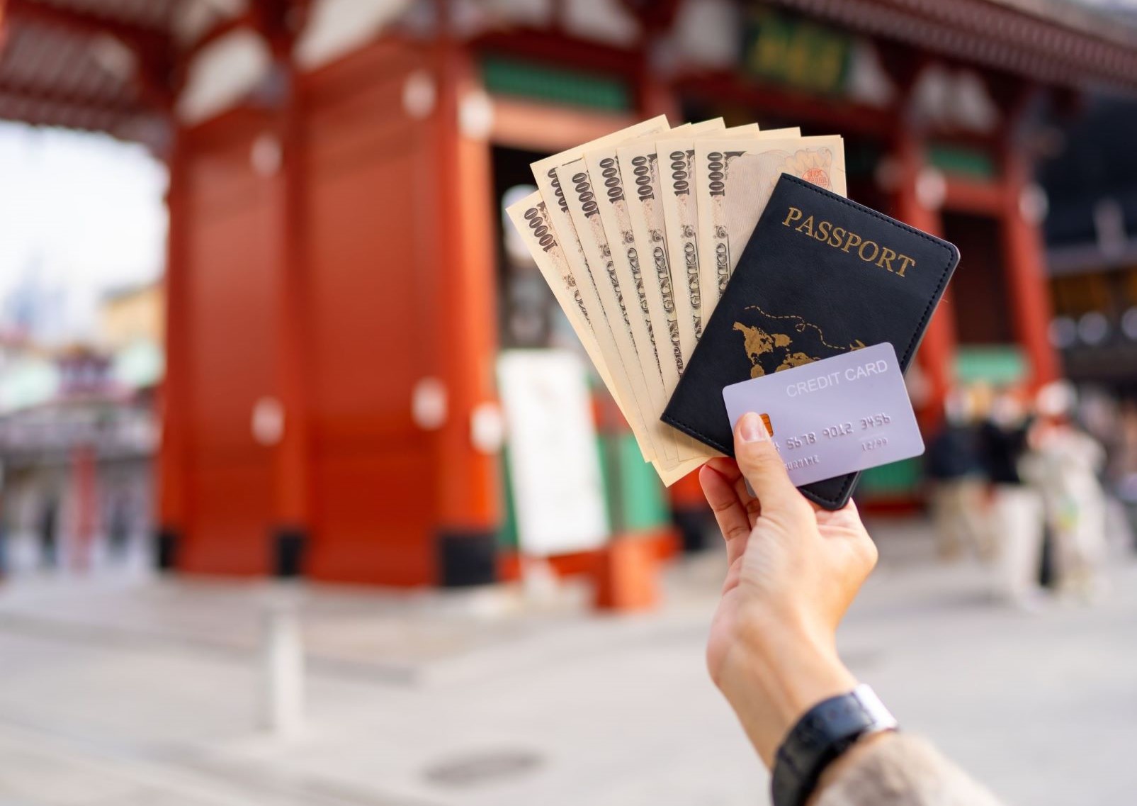 Woman holding passport, banknote and credit card at Sensoji Temple, Tokyo, Japan