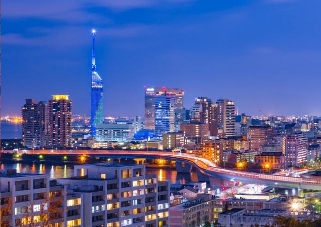 City of Hakata in Fukuoka, Japan at twilight with a blue hue and twinkling city lights