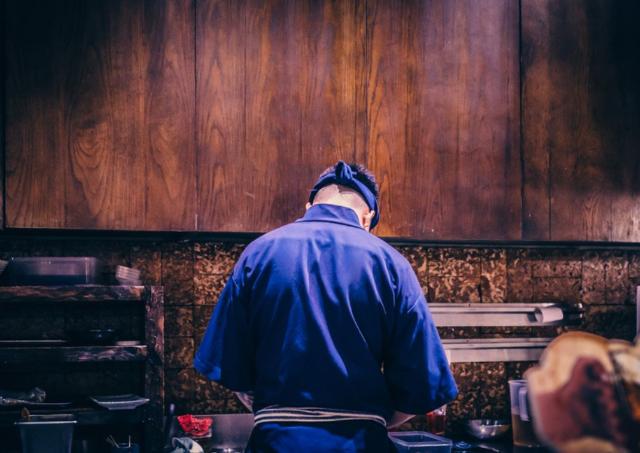 A ramen chef making soup in a kitchen