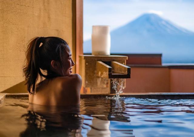 Lady in a private onsen looking out the wiindow at Mount Fuji