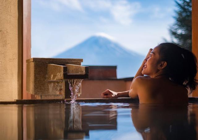 Lady in a private onsen looking out the wiindow at Mount Fuji
