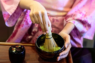 Lady in kimono making Japanese green tea 