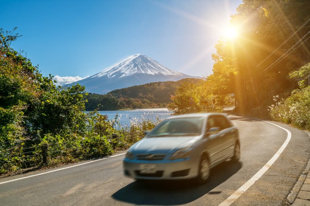 Car driving near Mt Fuji in Japan with motion blur showing rapid movement on a highway road at Lake Kawaguchiko
