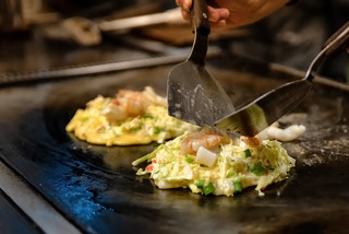 Cooking okonomiyaki on steel plate 