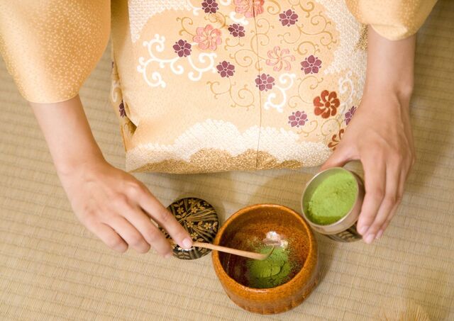 Lady in kimono conducting Japanese tea ceremony