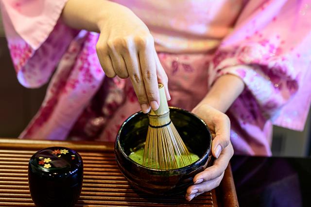Lady in kimono making Japanese green tea